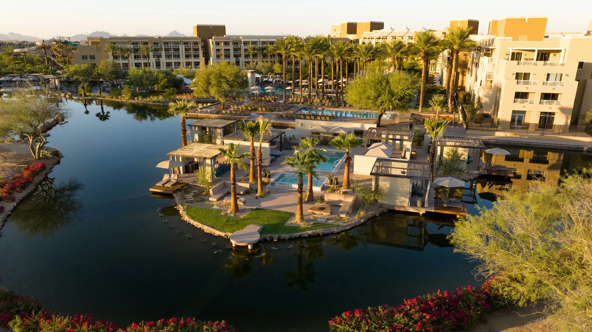 Aerial view of the resort lagoon, island pool, and desert mountain backdrop